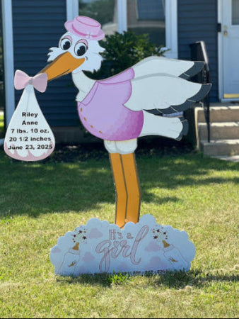 Stork decoration with baby announcement sign in front of a house